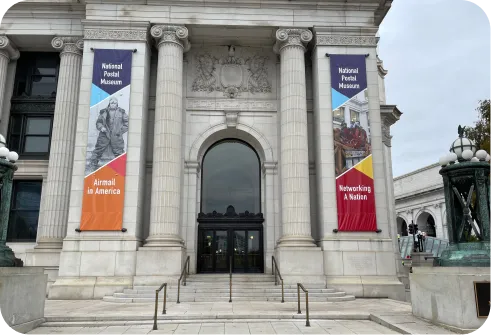 Exhibition banners mounted beside the entrance of a museum.