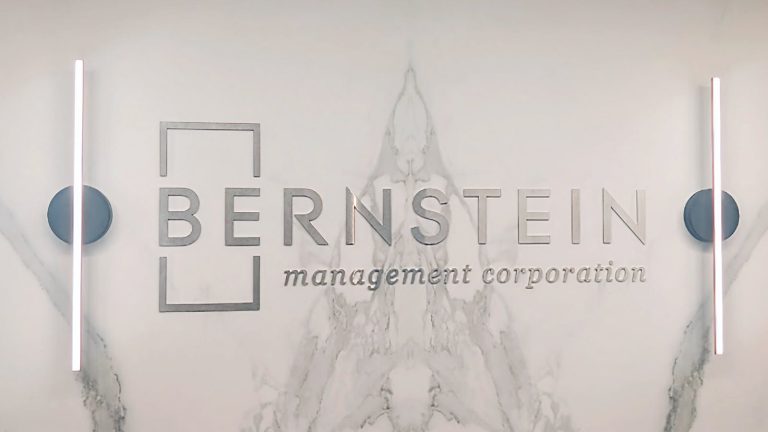 Bernstein Management Corporation logo lettering mounted on a light-colored lobby wall.