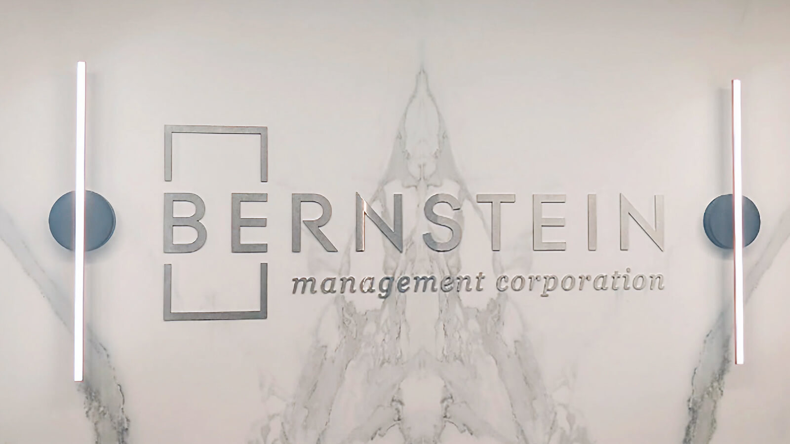 Bernstein Management Corporation logo lettering mounted on a light-colored lobby wall.
