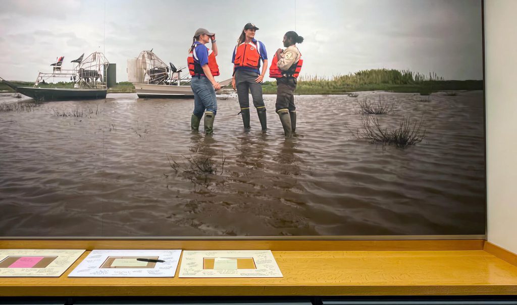 Visitors standing in water in a United States Fish and Wildlife exhibit photograph.