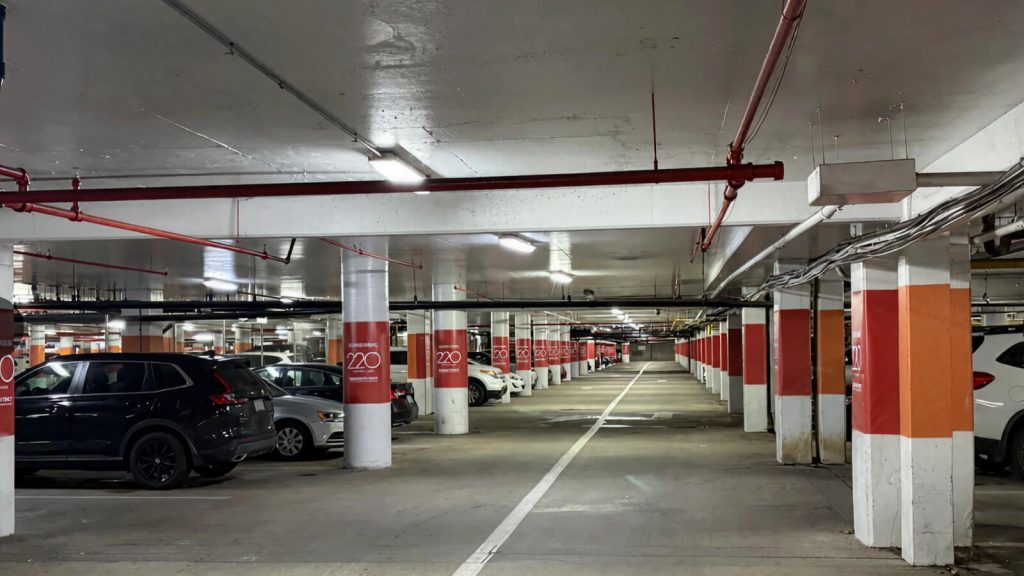 Red and white parking column wraps throughout a JBG SMITH garage.