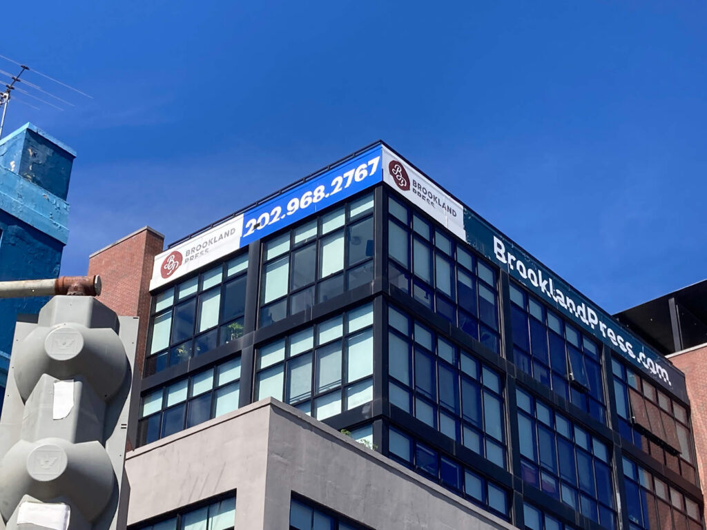 Brookland apartment building with large rooftop leasing signage.