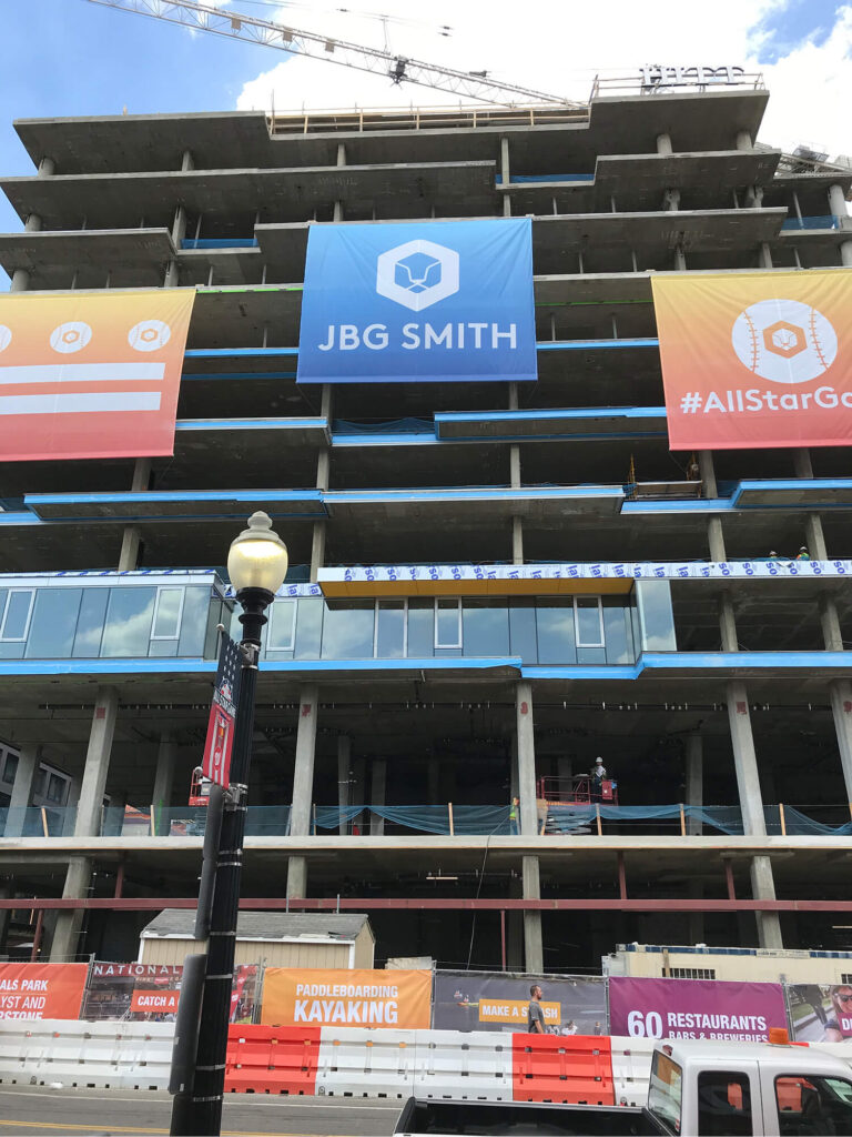JBG SMITH and leasing banners mounted on a building under construction.
