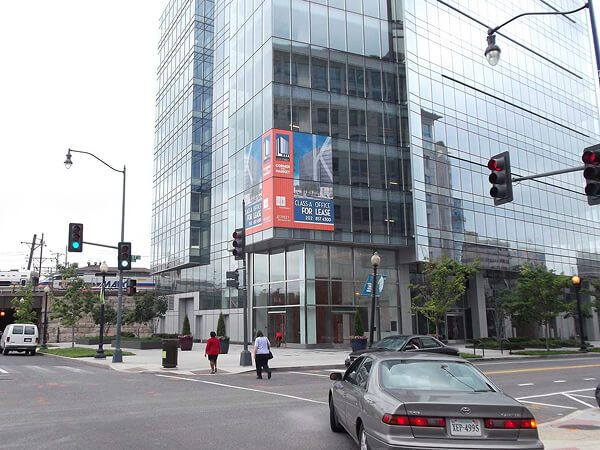 Large promotional window graphics on the corner of a glass office building.