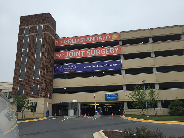Hospital advertising banners mounted on a parking garage facade.