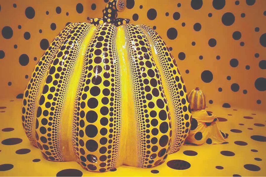 Yellow pumpkin with black dots in a Yayoi Kusama installation.