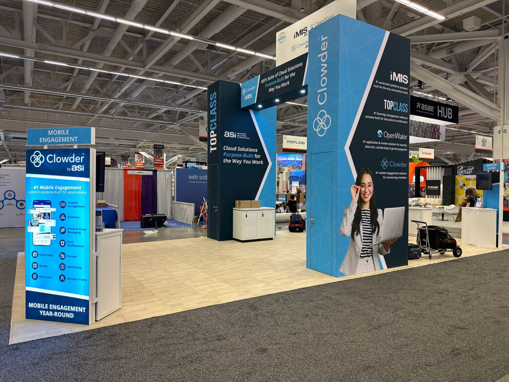 Software exhibition booth with branded display towers, counters and digital screens.