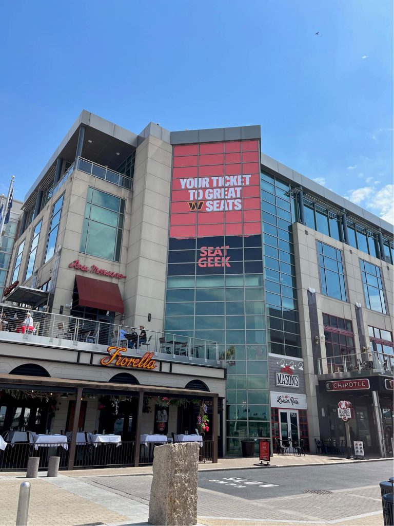 Large red event banner installed on the exterior of an arena building.