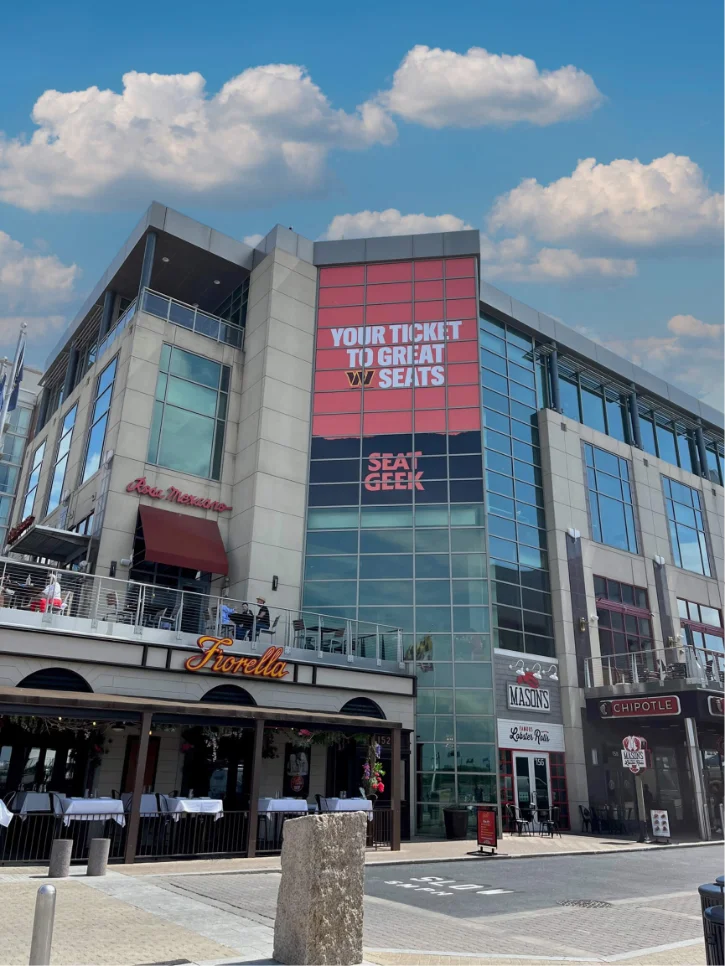 Large red event banner installed on the exterior of an arena building.