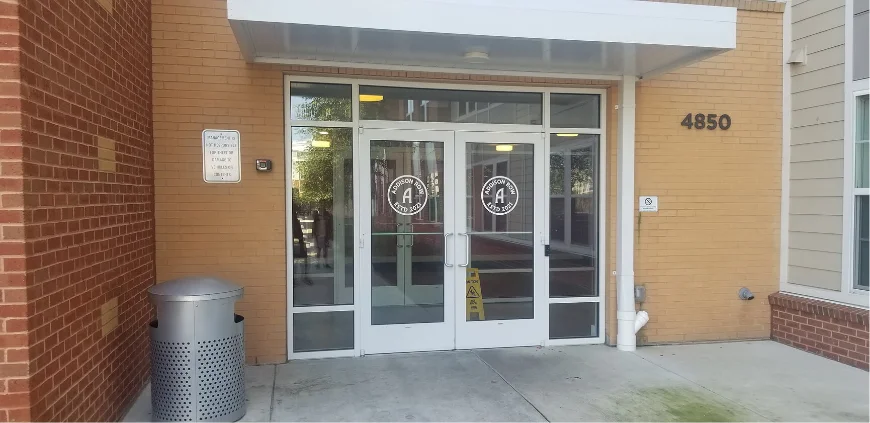 Branded window graphics on the glass entrance doors of an office building.