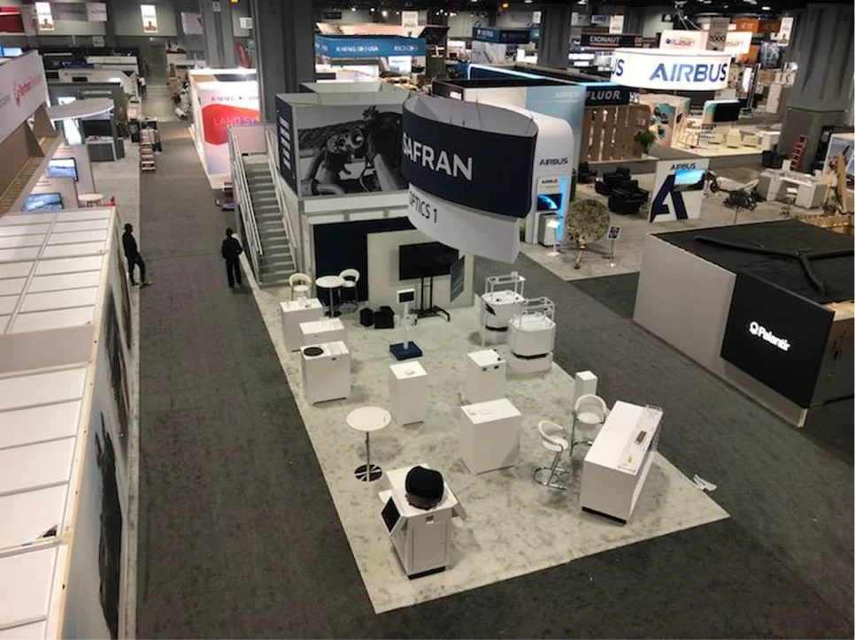 Exhibition booths and branded display counters viewed from above.