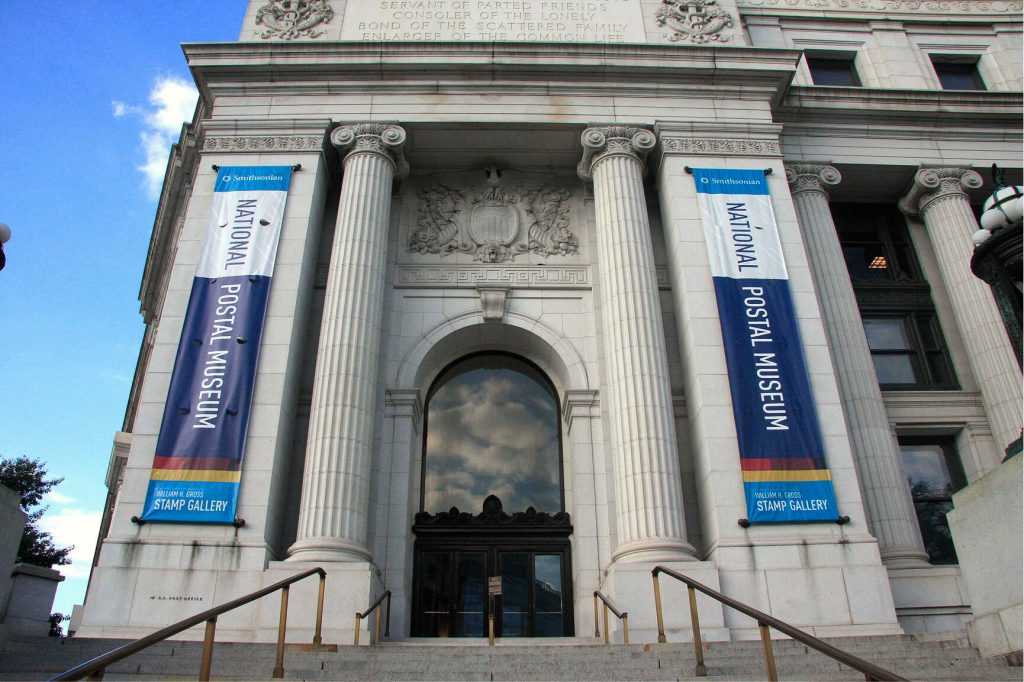 Exhibition banners mounted beside the entrance of a museum.